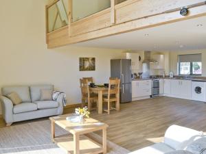 a living room with a couch and a table at Orchid Lodge in Hainford