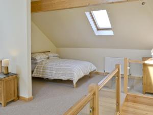 a attic bedroom with a bed and a skylight at Orchid Lodge in Hainford