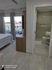 um quarto com uma cama e uma casa de banho com um WC em Hotel Serrano em Frederico Westphalen