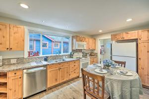 a kitchen with wooden cabinets and a table and a refrigerator at Port Angeles Retreat - 1 Mi to Downtown! in Port Angeles