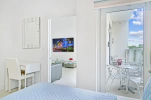 um quarto branco com uma mesa, cadeiras e uma cama em Miami Brickell 4 Bedrooms High Ceiling loft on the pool em Miami