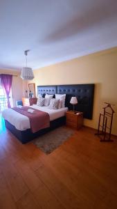a bedroom with a large bed with a blue headboard at DOWNTOWN-Guest House in Olhão