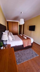 a bedroom with a large bed and a tv at DOWNTOWN-Guest House in Olhão