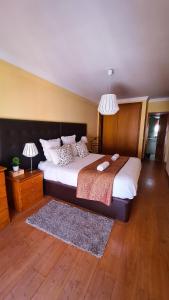 a bedroom with a large bed with two lamps and a rug at DOWNTOWN-Guest House in Olhão