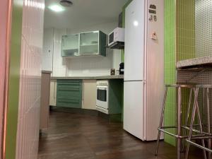 eine Küche mit grünen und weißen Schränken und einem Kühlschrank in der Unterkunft Apartamento valencia centro in Valencia