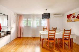 une salle à manger avec une table et des chaises blanches dans l'établissement Modern design apartament in Conil!, à Conil de la Frontera