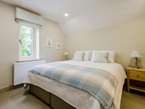 a white bedroom with a large bed and a window at Rectory Cottage in Blankney