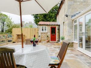 Rectory Cottage في Blankney: طاولة مع مظلة على الفناء