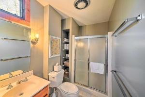 a bathroom with a shower and a toilet and a sink at Lakefront Harrison Home with Sunroom, Deck, and Dock! in Ooltewah +31 photos