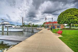 a red bench next to a marina with a boat at Downtown Grand Haven Apt Less Than 1 Mi to Lake Michigan in Grand Haven