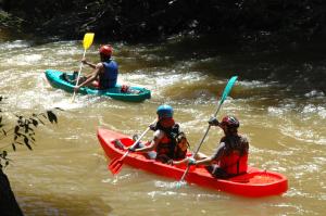 three people are in kayaks on a river at Estalagem das Estrelas in Cristalina