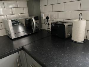 La cocina está equipada con microondas y tostadora. en Room 2 Peaceful stay Near Derby City Centre, en Derby