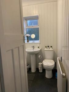 ein Bad mit einem Waschbecken, einem WC und einem Fenster in der Unterkunft Room 2 Peaceful stay Near Derby City Centre in Derby
