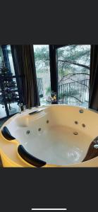 a large bath tub in a room with a window at Exclusive Jacuzzi Apartaments Klaipėda in Aukštkiemiai