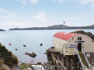 a building on the side of a body of water with boats at Brook View - Hw7477 in Penybont