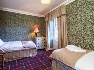 um quarto de hotel com duas camas e uma janela em Lochenkit Farmhouse em Corsock