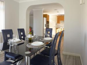 a dining room with a table with chairs and wine glasses at Woodside in Burton