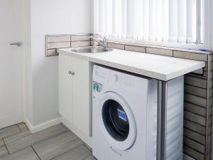 a washing machine in a kitchen with a sink at Woodside in Burton