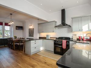 a kitchen with white cabinets and a black stove top oven at The Laburnums in Askham