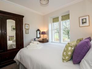 a bedroom with a large white bed and a large window at The Laburnums in Askham