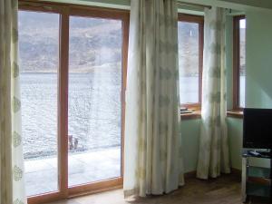 a room with a window with a view of the water at Island Bay View in Sallachy