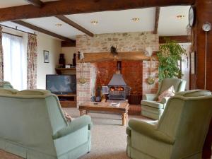 a living room with chairs and a fireplace at The Granary in Colyford