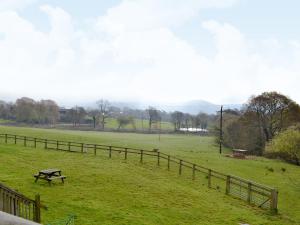 a picnic table in a field next to a fence at The Granary in Colyford