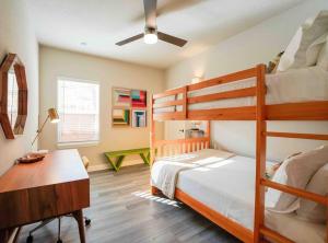 Un dormitorio con dos literas y un escritorio. en Casa Lavaca Luxury, en San Antonio