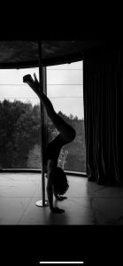 a woman doing a handstand in front of a window at Exclusive Jacuzzi Apartaments Klaipėda in Aukštkiemiai