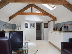 a kitchen and living room with a glass table at Hound Cottage in Burford