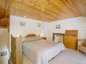 a bedroom with a bed and a wooden ceiling at The Old Laundry in Balnaboth