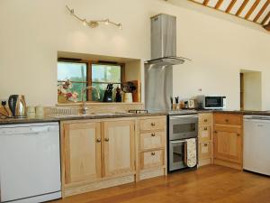 a kitchen with white appliances and wooden cabinets at Mashers Barn in Bucknell
