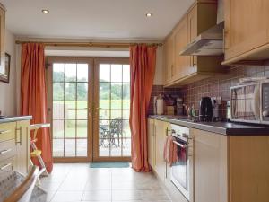 uma cozinha com uma porta aberta para um pátio em The Ploughmans - Uk5531 em Kepculloch