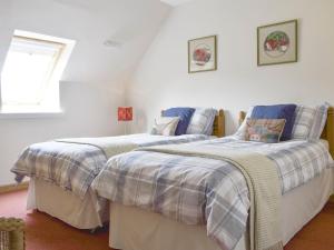 2 camas individuais num quarto com paredes brancas em The Ploughmans - Uk5531 em Kepculloch