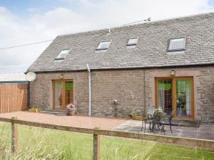 a stone cottage with a patio in front of it at The Ploughmans - Uk5531 in Kepculloch
