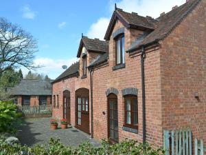 ein rotes Backsteinhaus mit vielen Fenstern in der Unterkunft Pear Tree Cottage in Kinlet