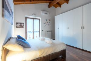 - une chambre avec un grand lit blanc et des oreillers bleus dans l'établissement [10' from Malpensa] Shuttle, Netflix & Wi-Fi, à Casorate Sempione
