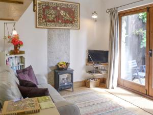 a living room with a couch and a fireplace at The Figgery in Wrangaton