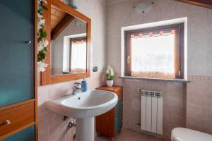 a bathroom with a sink and a mirror and a window at [10' from Malpensa] Shuttle, Netflix & Wi-Fi in Casorate Sempione +13 photos
