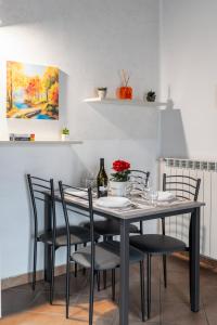une table à manger avec des chaises et un tableau dans l'établissement [10' from Malpensa] Shuttle, Netflix & Wi-Fi, à Casorate Sempione