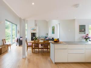 a kitchen and dining room with white cabinets and a table at Tigh An Iasgair in Fearnmore