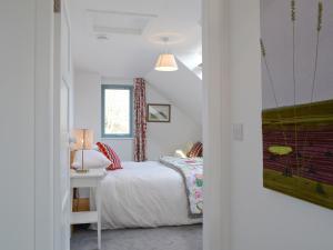Tigh An Iasgair في Fearnmore: غرفة نوم بسرير وطاولة مع مصباح