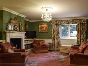 a living room with a couch and a fireplace at The Coach House in Great Easton