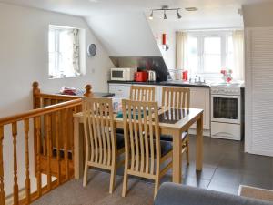 a kitchen with a table and chairs in a kitchen at Iris Apartment in Stalham