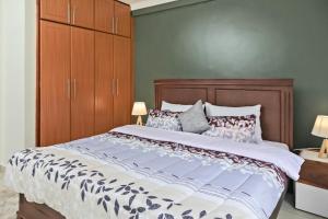 a bedroom with a large bed with a wooden headboard at Cozy 2B&B with Free Airport Pick up & Drop off in Namugongo