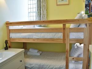a bedroom with two bunk beds in a bathroom at Howegrain Lodge in Glenridding