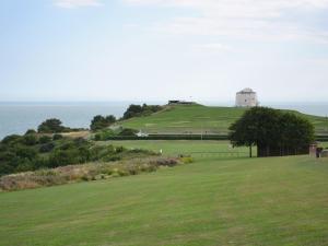 a grassy hill with a lighthouse on top of it at Treacle Cottage At Treacle Den - E5385 in Lympne