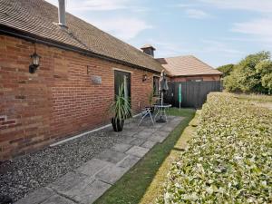 a brick house with a table and a patio at Treacle Cottage At Treacle Den - E5385 in Lympne