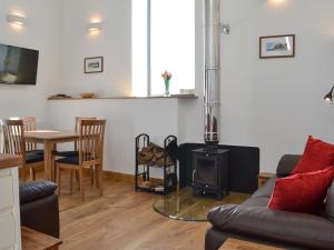 a living room with a couch and a stove at The Granary in Criccieth