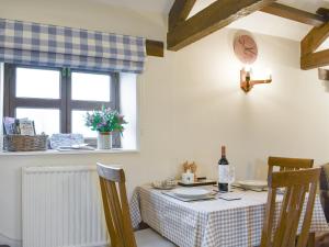 a dining room with a table and a window at Curlew Barn in Middleham